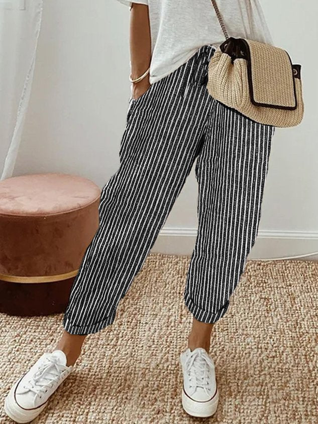 Pantalón fluido a rayas negro y gris, cintura fruncida y puños elásticos, bolsillos.