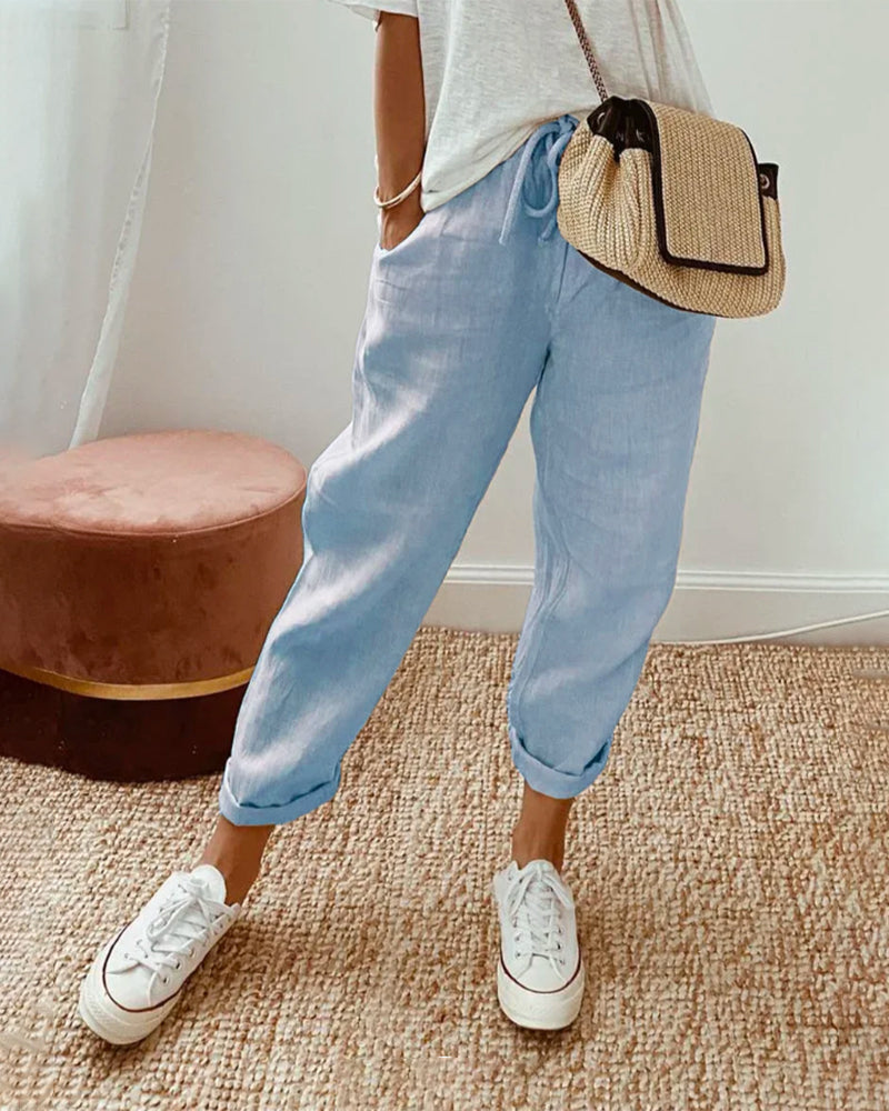 Pantalón fluido azul claro con cintura fruncida y puños elásticos, estilo casual.