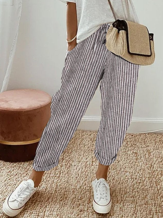 Pantalón fluido a rayas gris y blanco, cintura fruncida y puños elásticos, bolsillos.