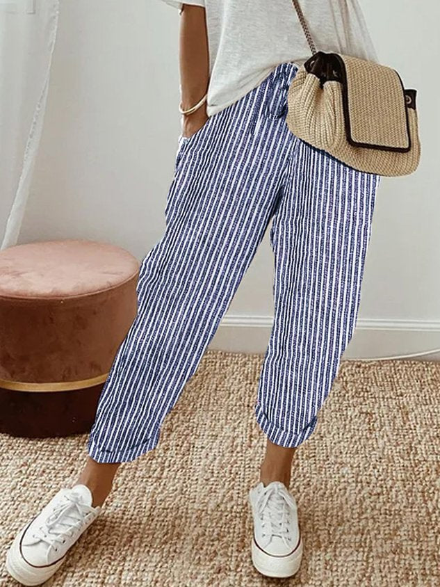 Pantalón fluido a rayas azul y blanco, cintura fruncida y puños elásticos, bolsillos.