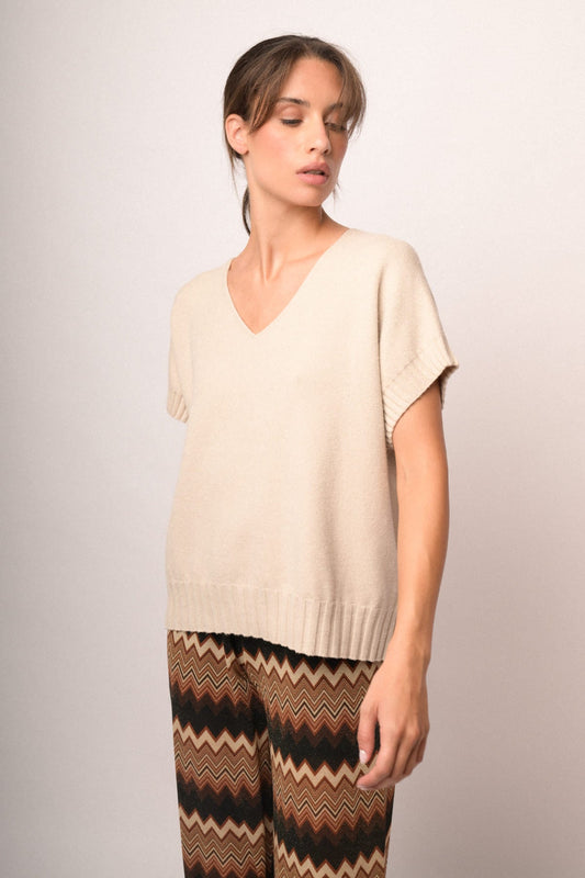 Chaleco de punto beige con escote en V y mangas cortas; bajo acanalado.