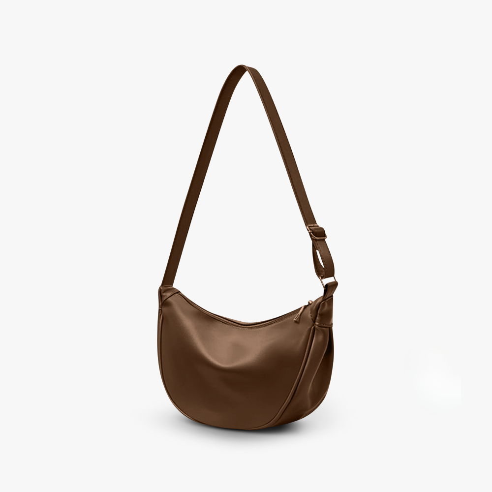 Bolso bandolera de piel sintética color café, forma media luna y asa ajustable