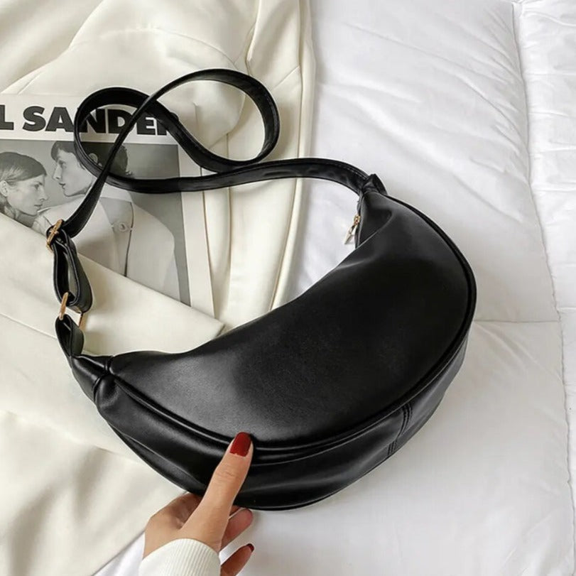 Bolso bandolera negro tipo media luna con correa larga y asa superior