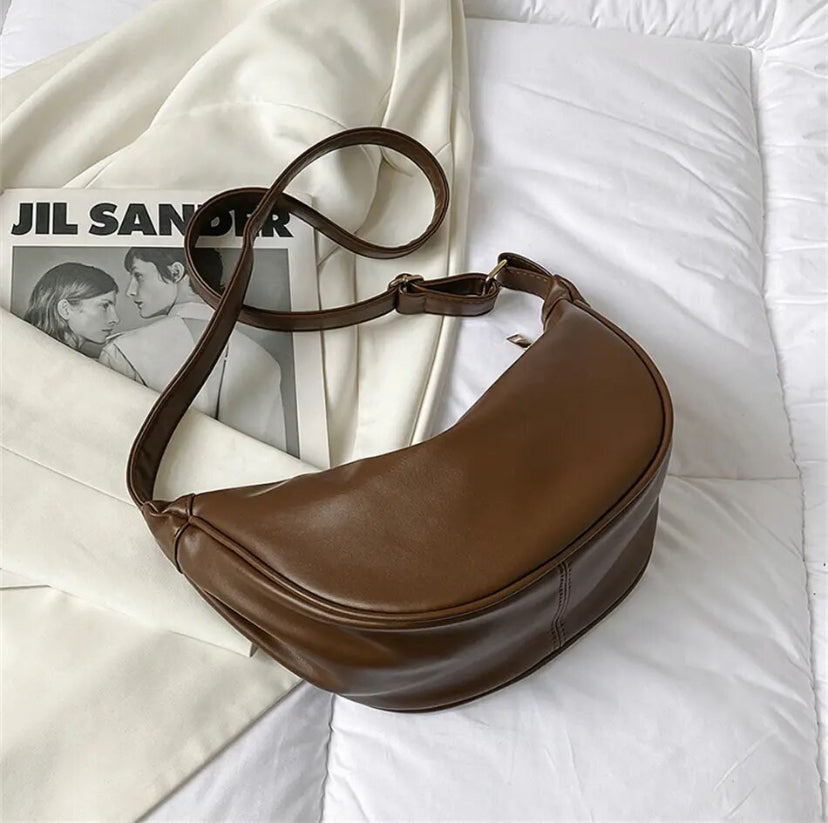 Bolso bandolera café tipo media luna, asas dobles y costuras en forma curva