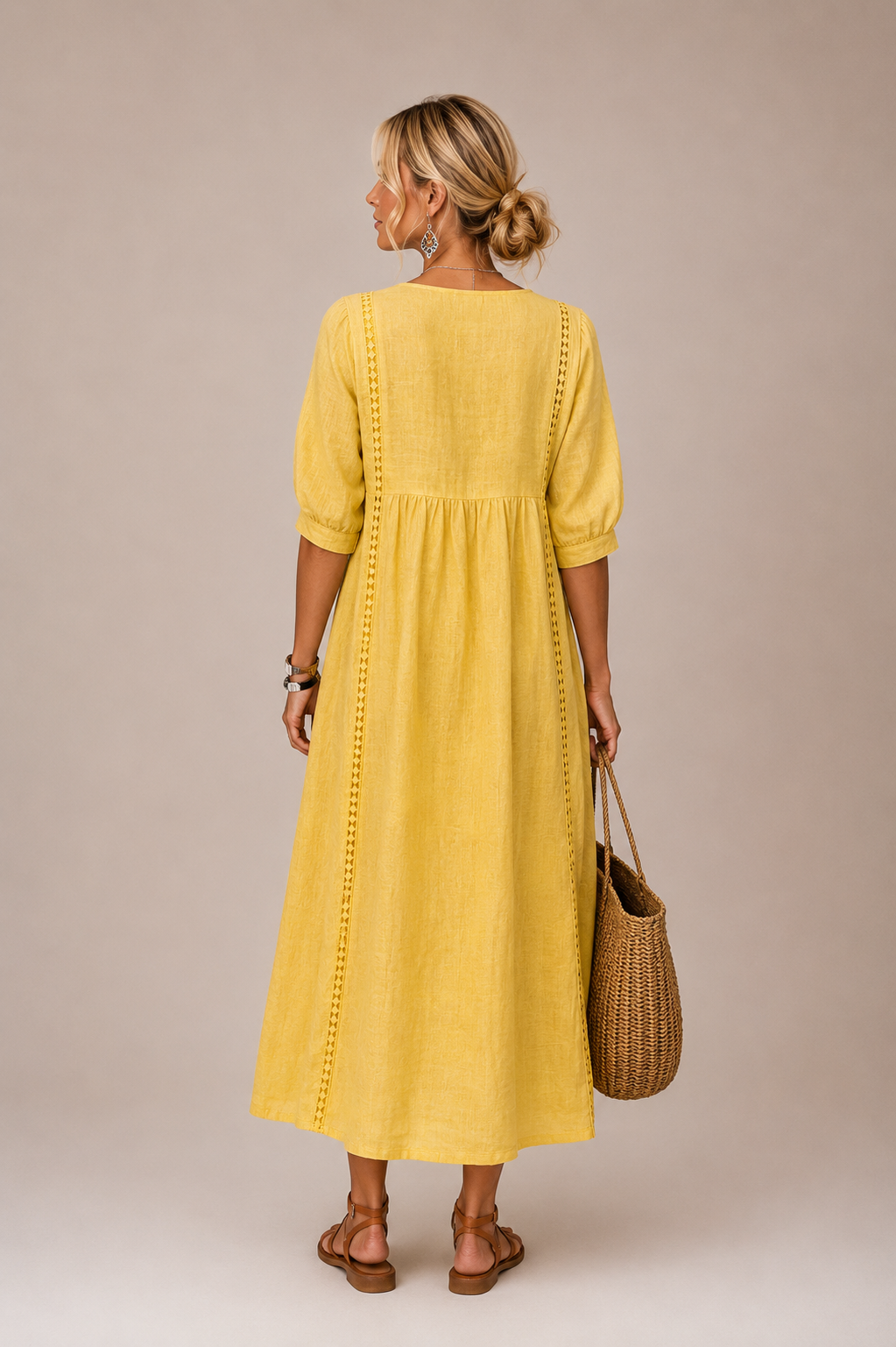 Vestido midi amarillo visto de espalda, con botones y costura vertical, mangas abullonadas.
