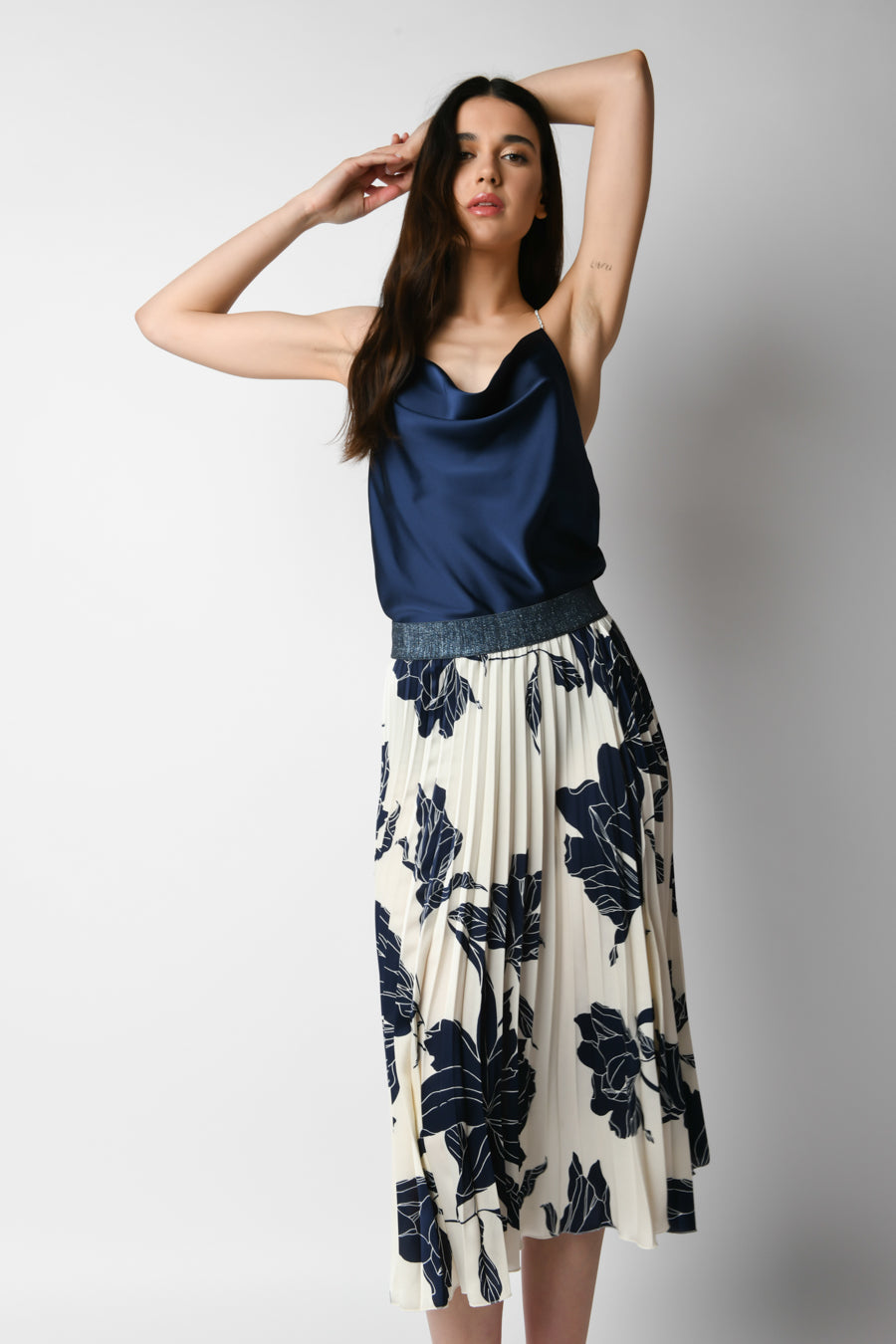 Falda midi plisada con estampado floral azul marino sobre fondo crema