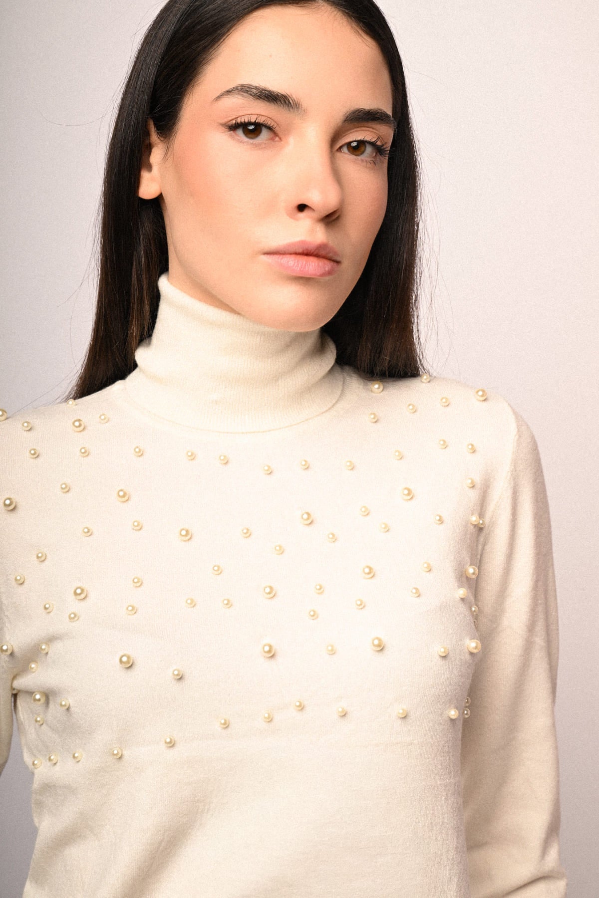 Jersey de cuello alto crema con apliques de perlas doradas