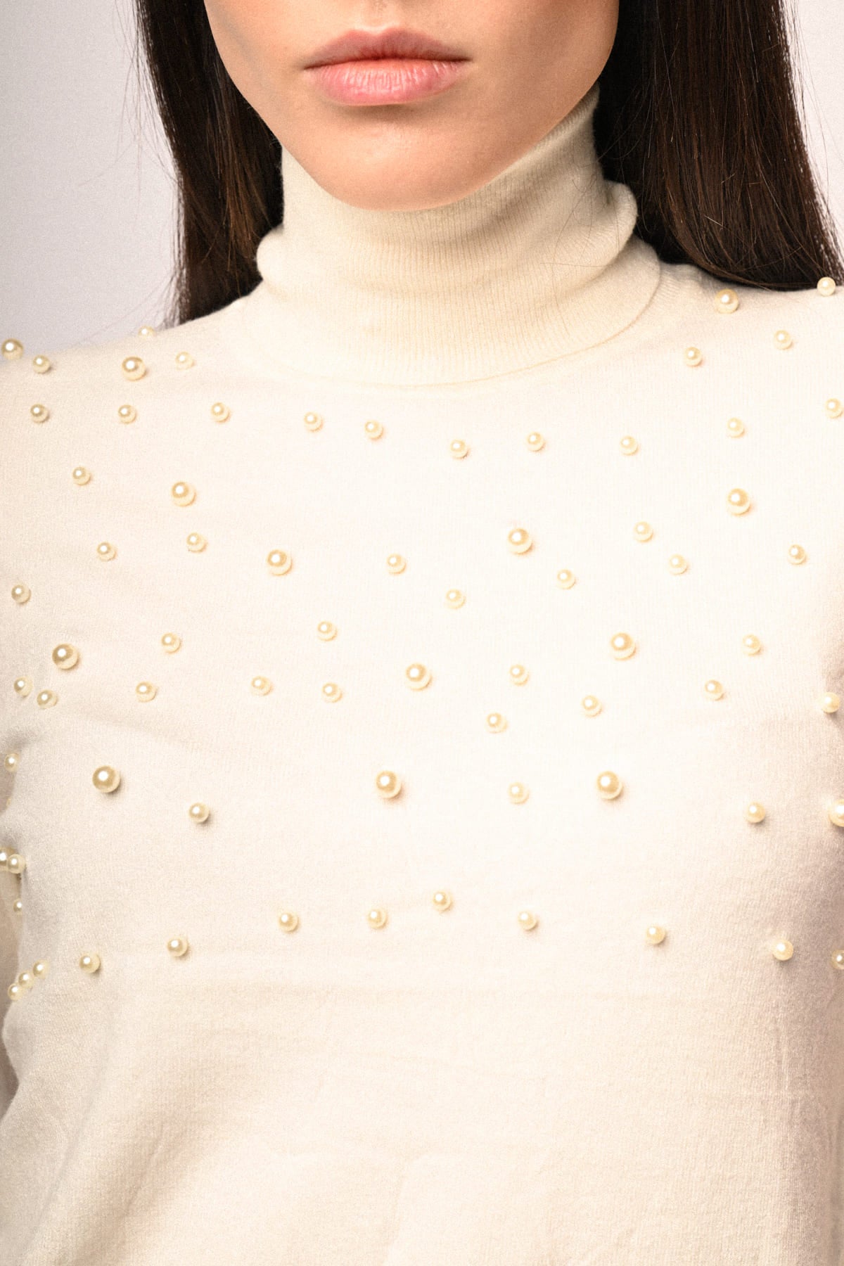 Jersey de punto crema con perlas doradas en la parte frontal y hombros