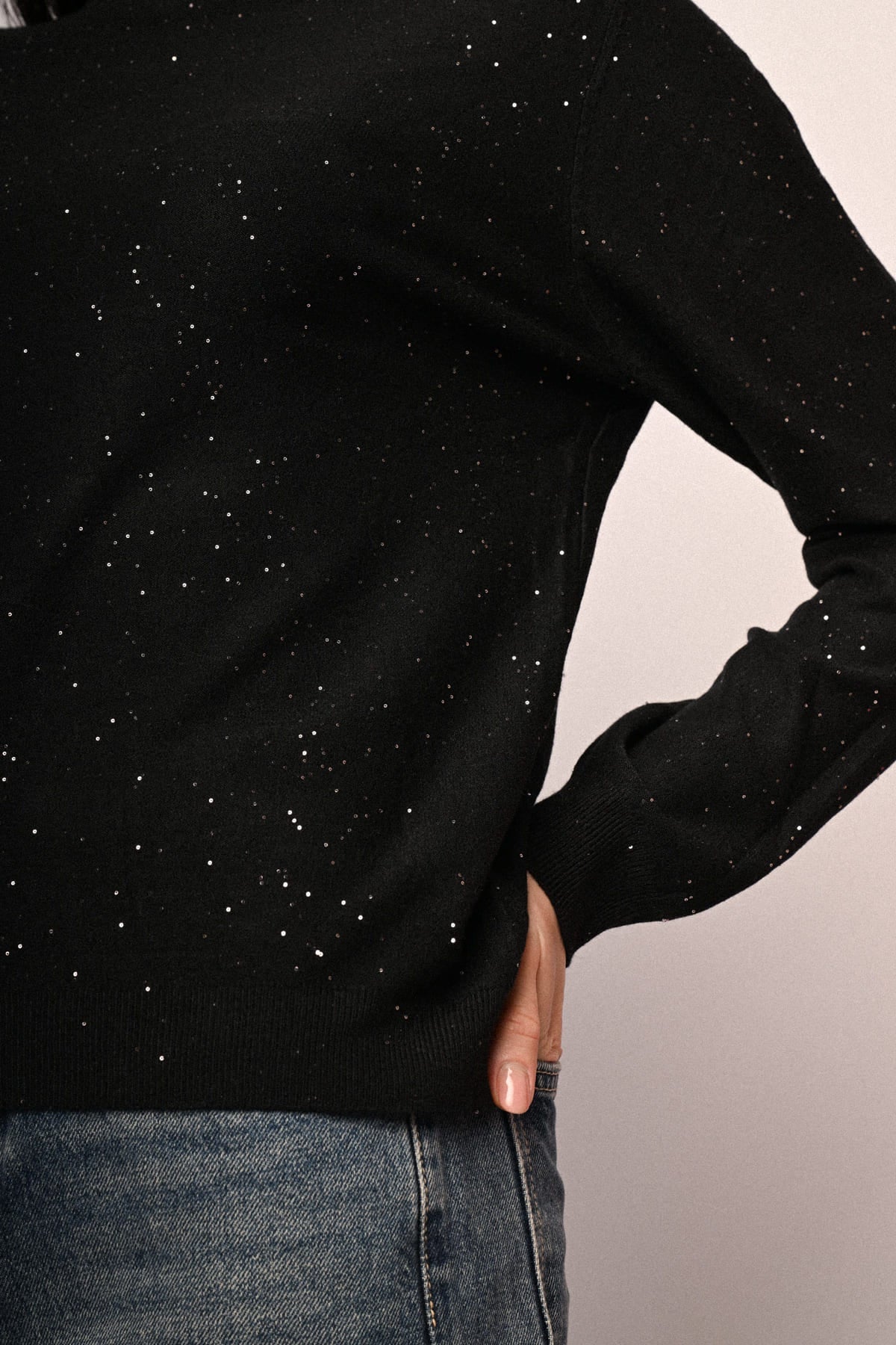 Jersey negro de cuello alto con lentejuelas brillantes, vista lateral