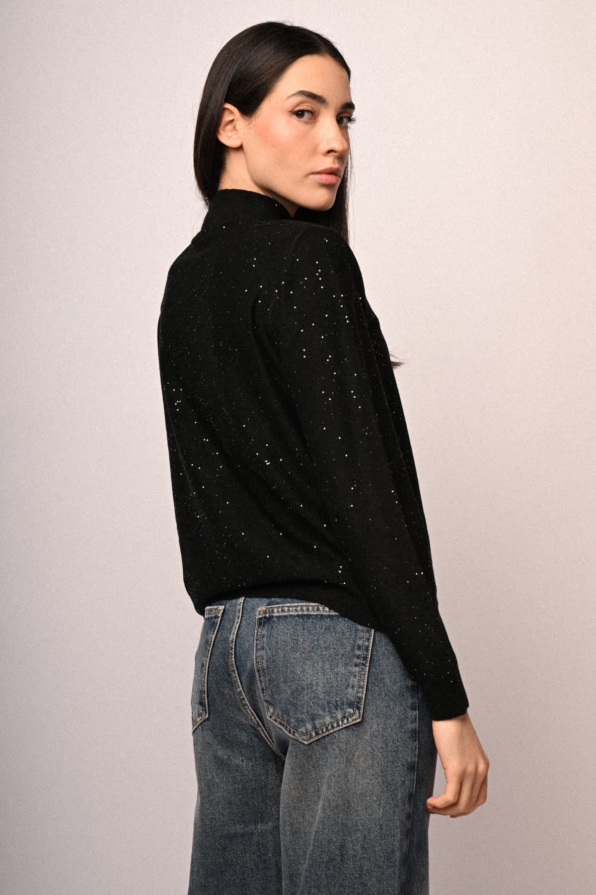 Jersey negro de cuello alto con lentejuelas, vista lateral con manga larga