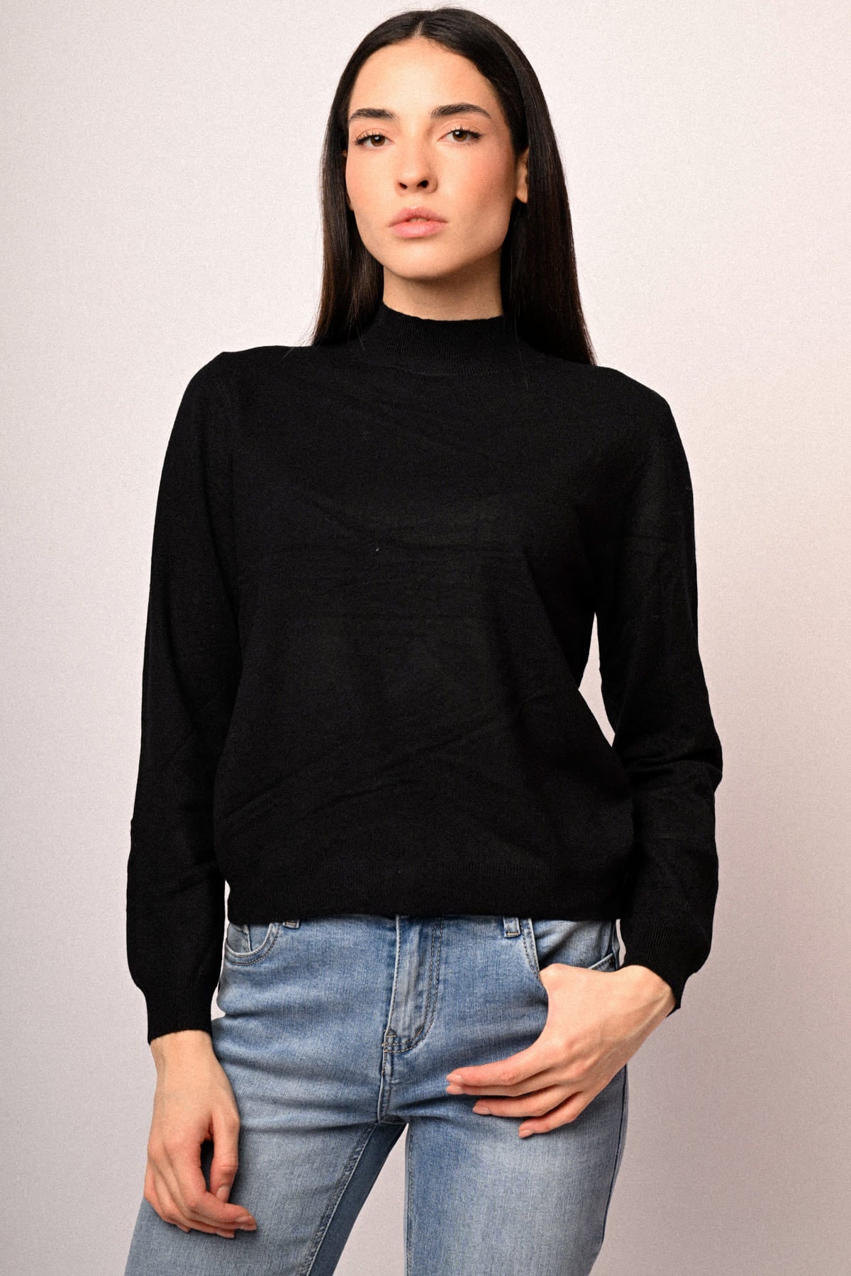 Jersey negro de cuello alto con manga larga, combinado con vaqueros