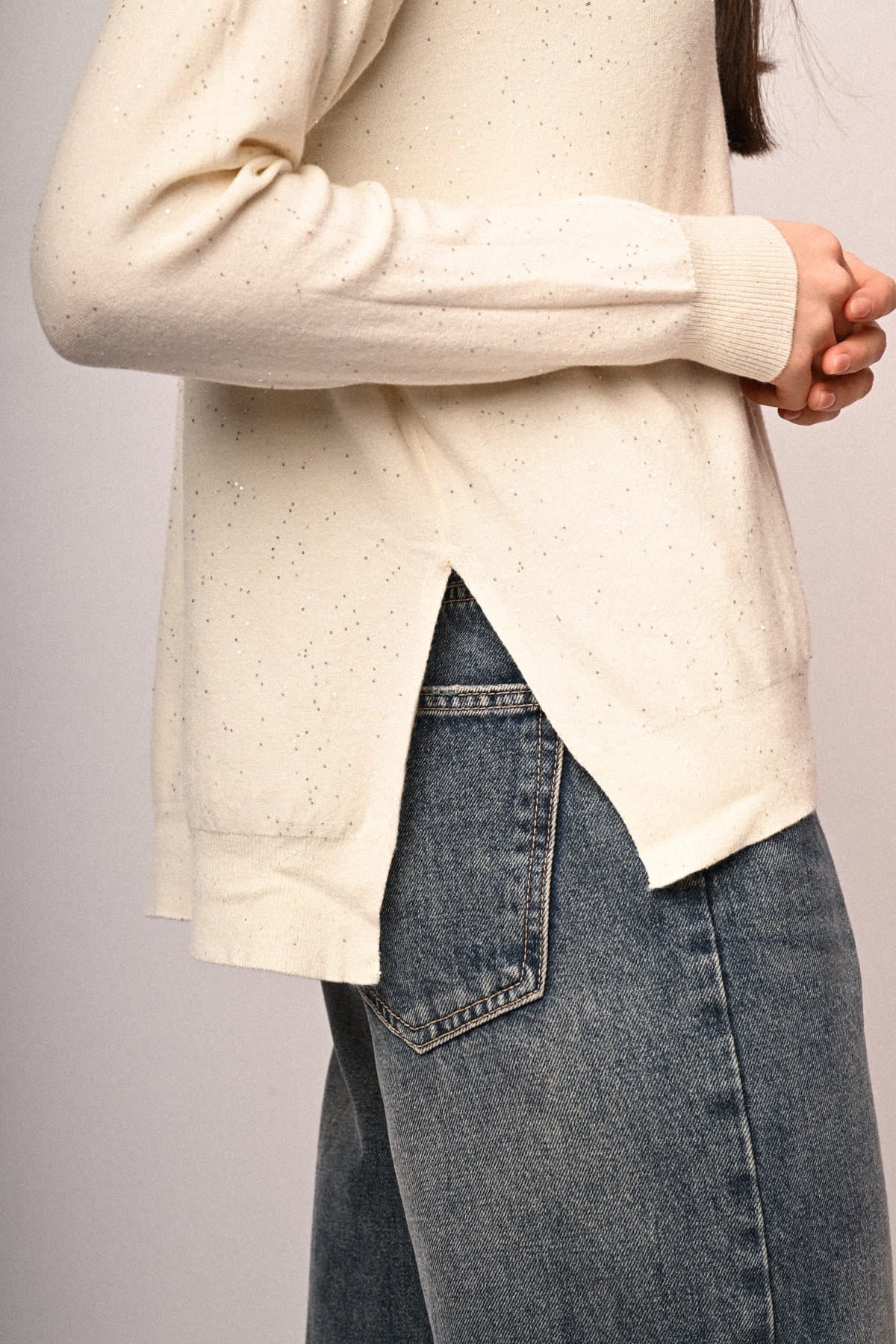 Jersey blanco con mini lentejuelas, detalle de abertura lateral y puño de punto