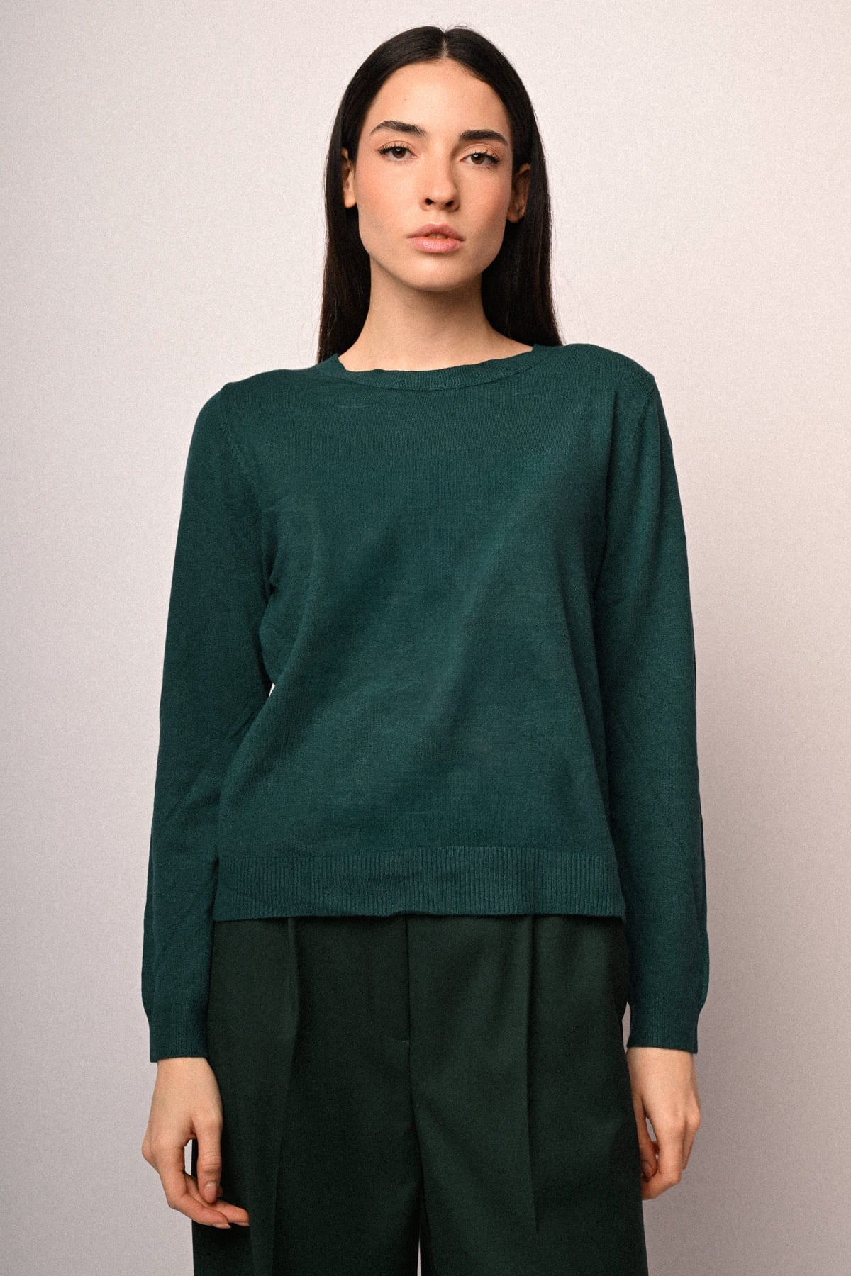 Jersey de punto verde oscuro con cuello redondo, manga larga y dobladillo recto