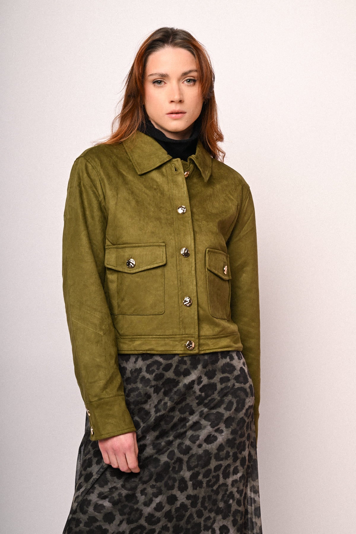 Chaqueta verde oliva de ante sintético con solapas y bolsillos con botones metálicos.