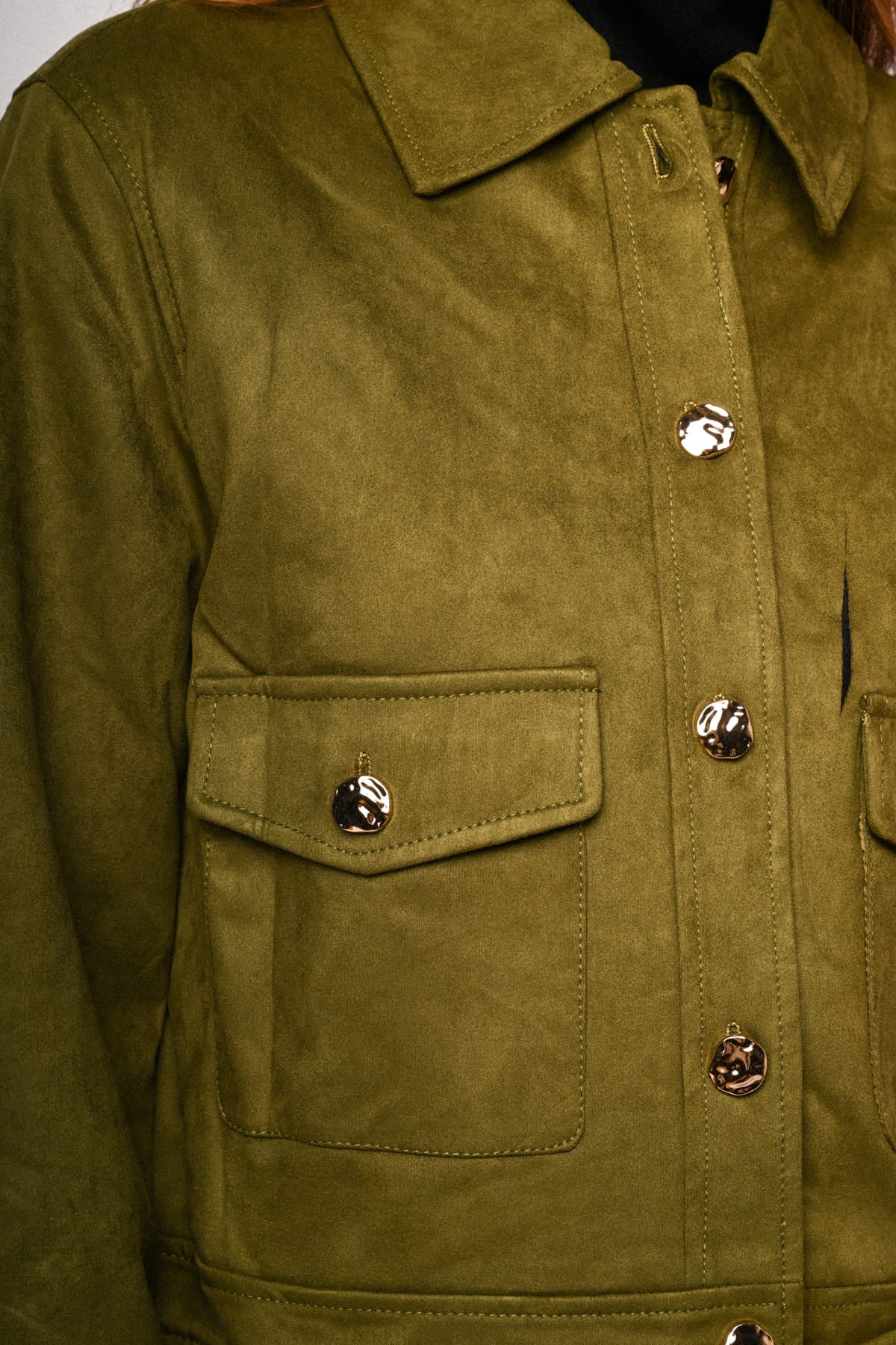 Chaqueta de ante sintético verde oliva: bolsillos con solapa y botones decorativos.