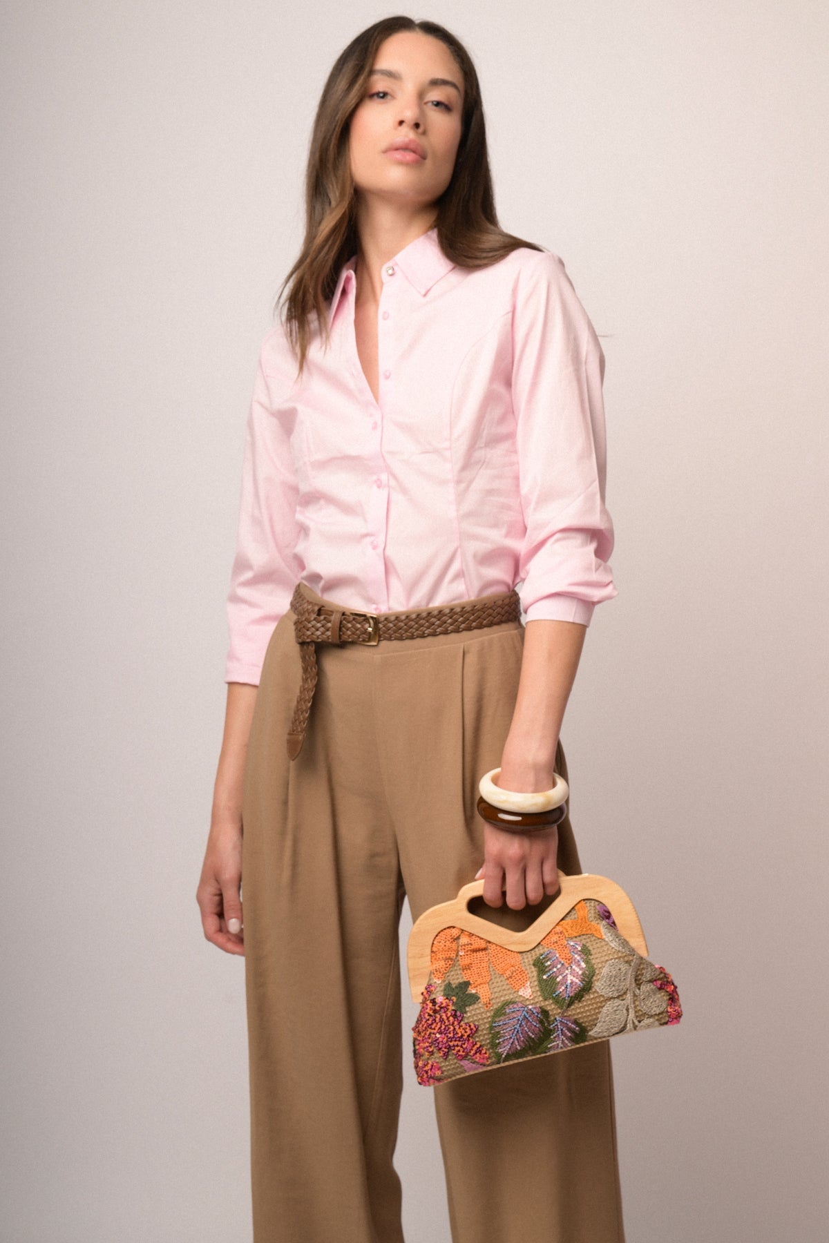 Camisa rosa con botones frontales, puños abotonados y dobladillo curvado