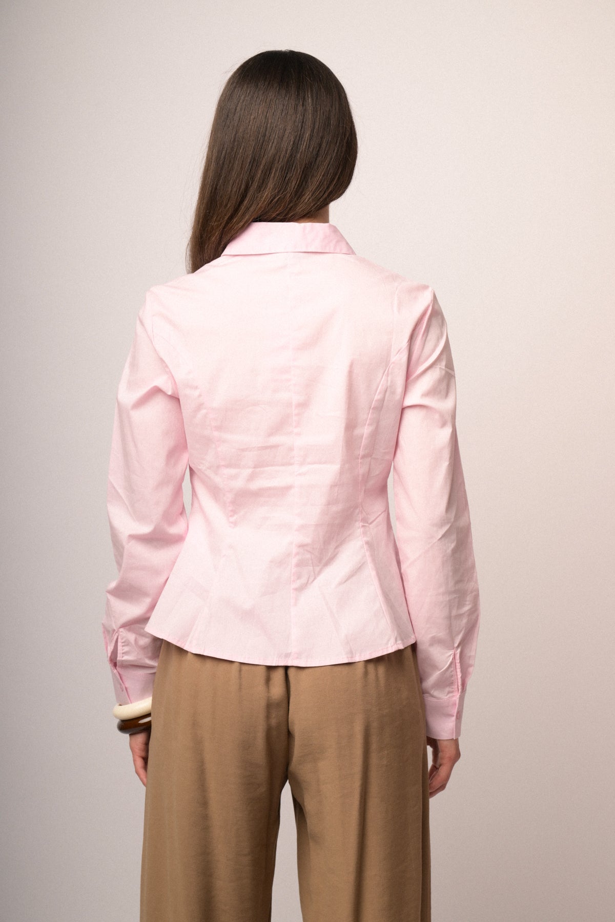 Camisa rosa de espalda con botones en la tapeta y cuello vuelto