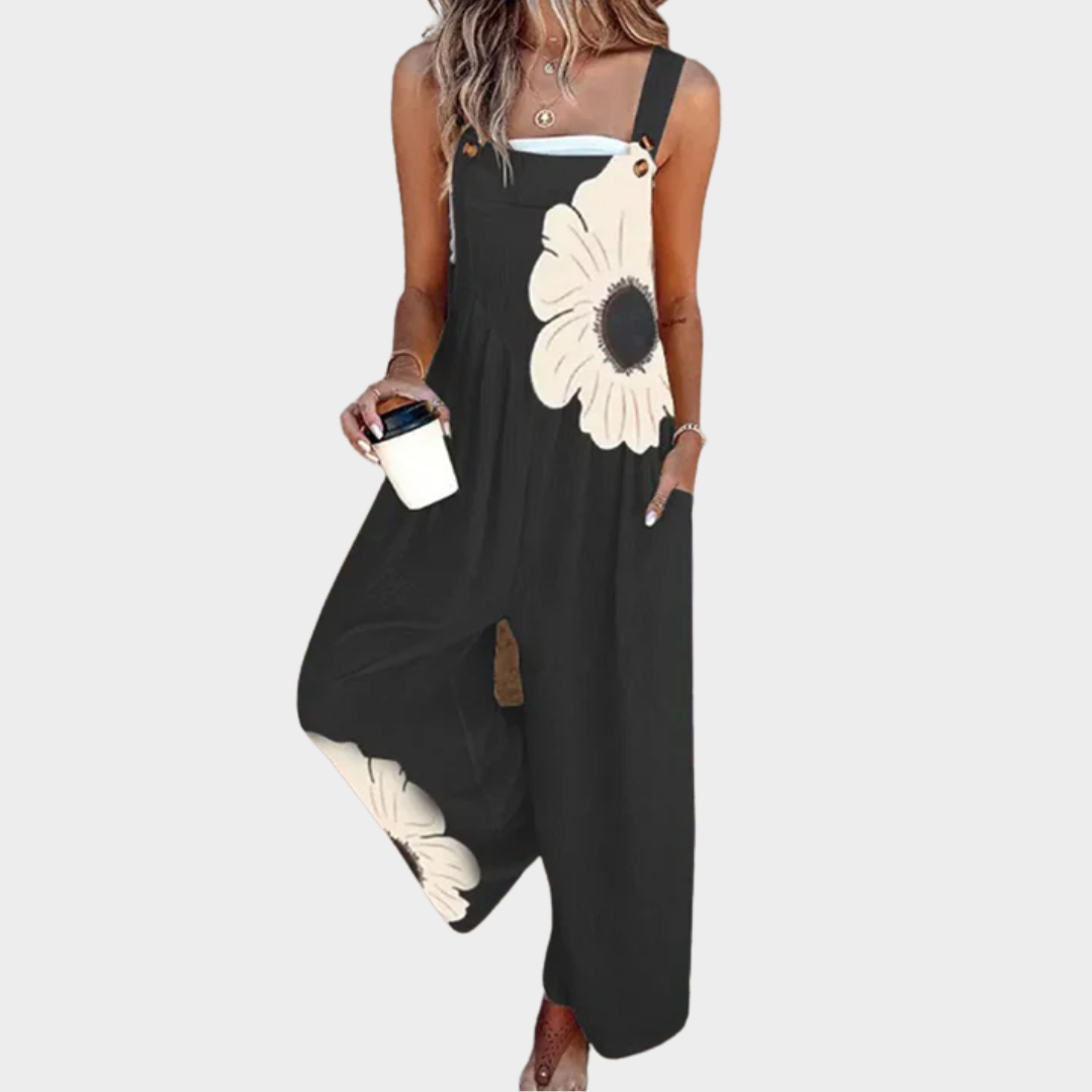 Mono sin mangas negro con flores blancas grandes y broche en el tirante