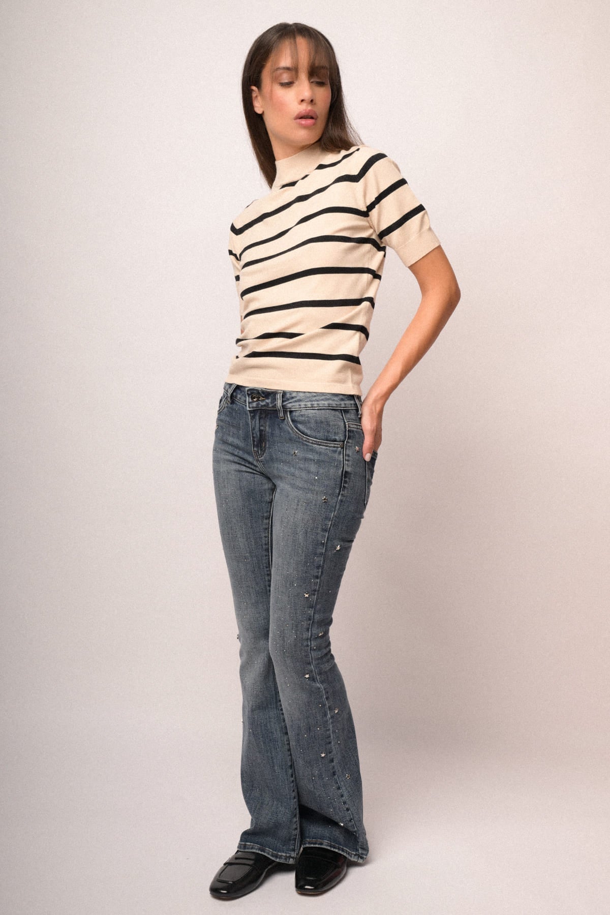 Jersey de cuello alto beige con rayas negras y manga corta, estilo casual