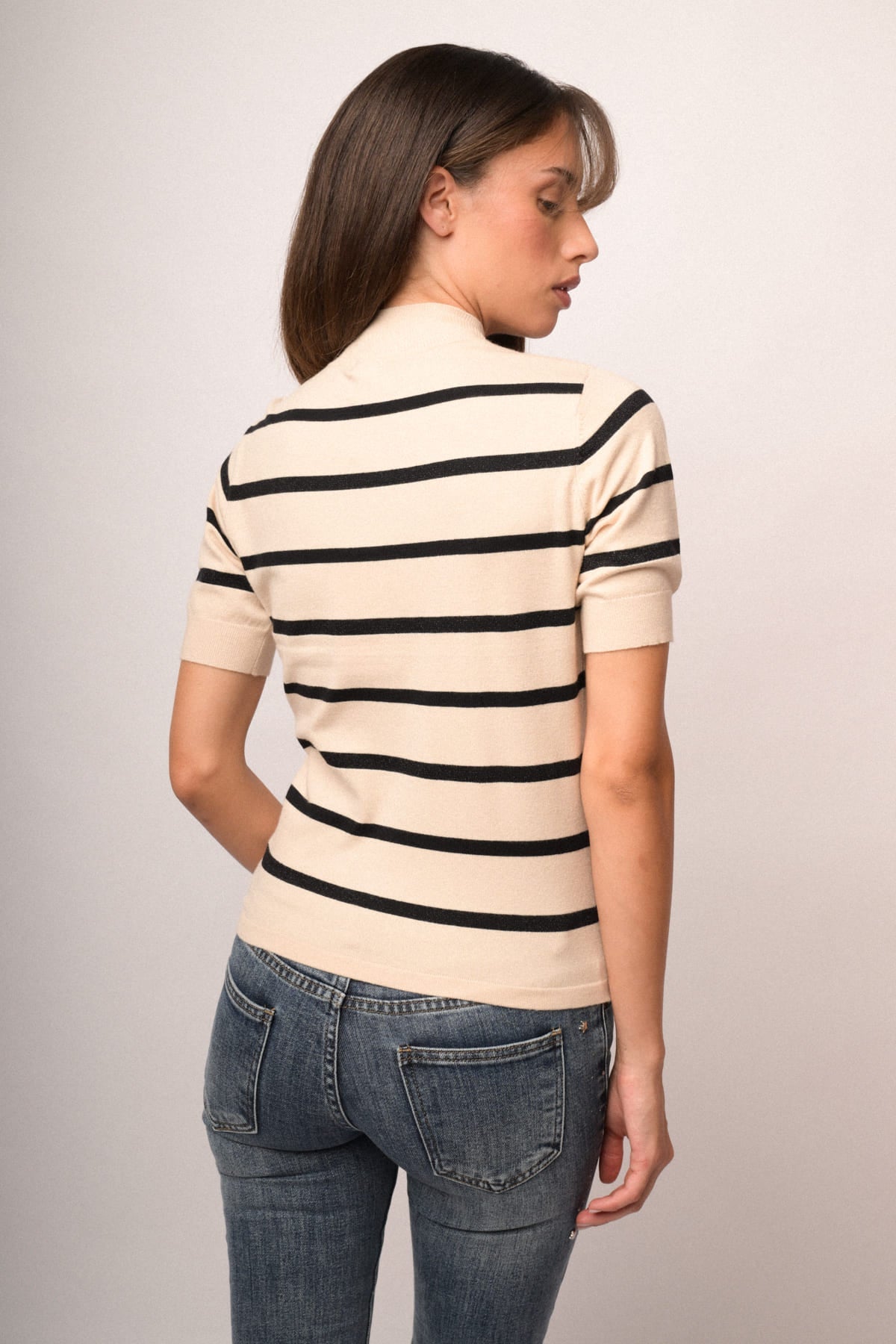 Jersey de cuello alto beige con rayas negras, vista trasera lateral