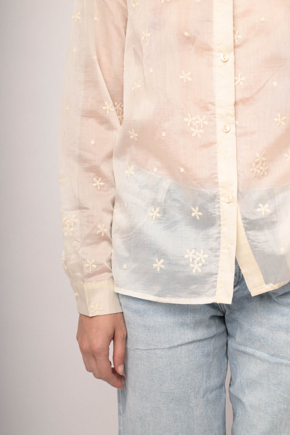 Camisa de muselina blanca con bordado floral dorado en el pecho y botones